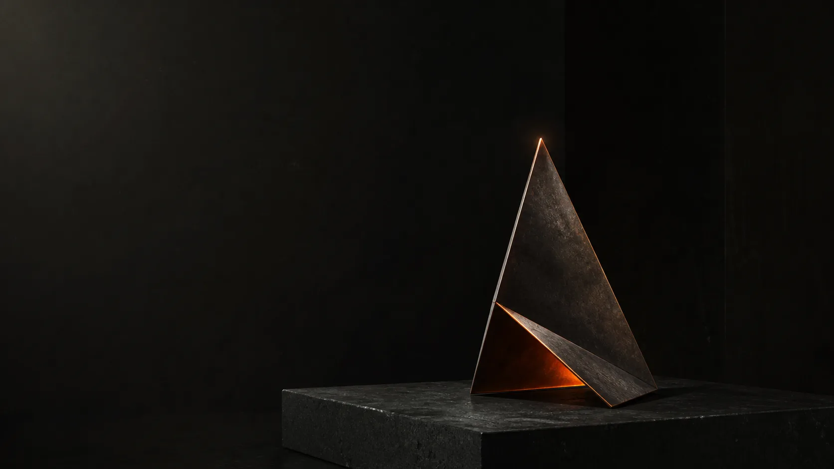 Piik – dunkle geometrische Skulptur mit warmem Licht